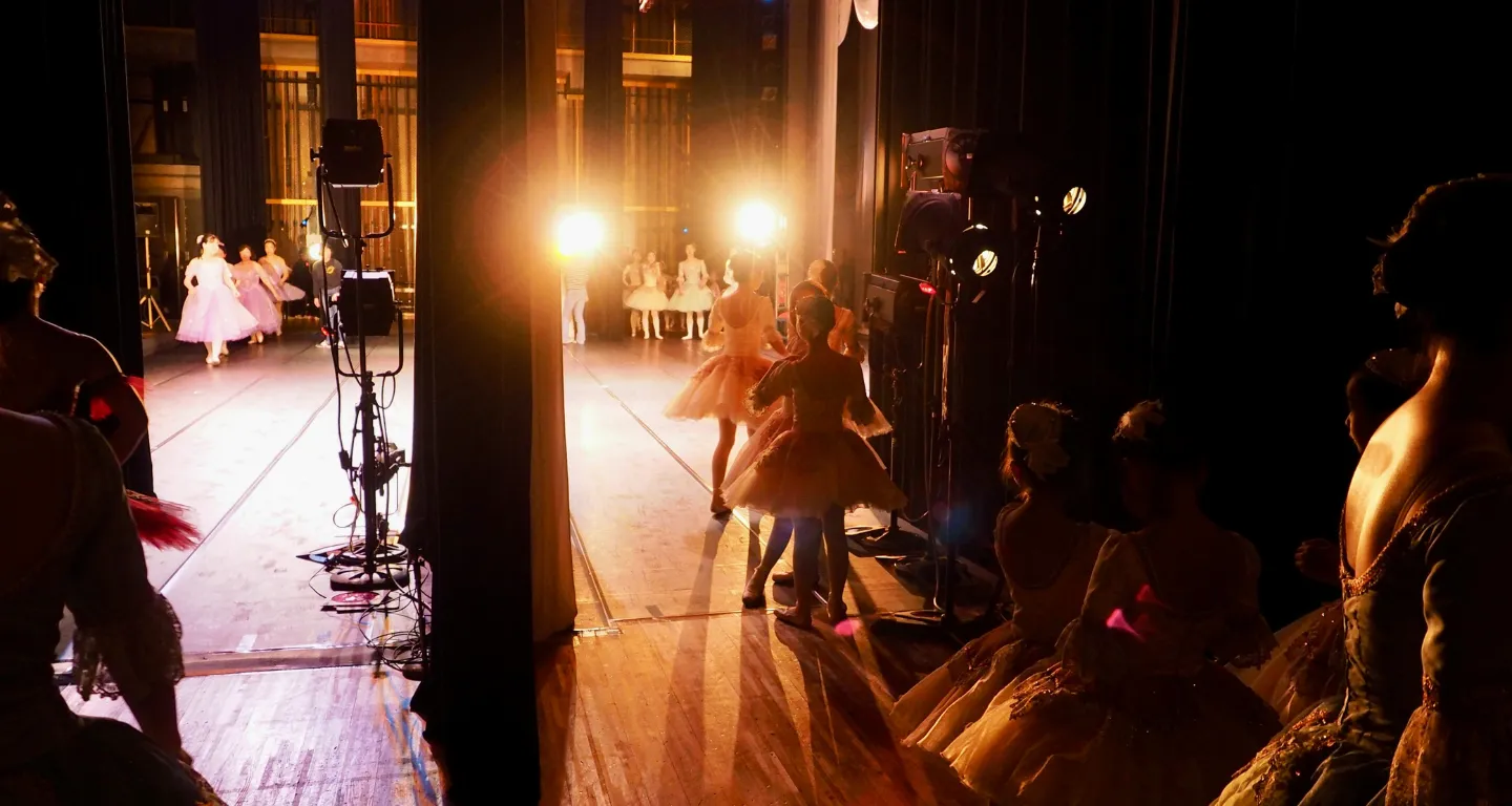 Backstage view of ballet dancers preparing to go on stage, illustrating how choreographers and directors use a storyboarding app to block scenes and plan stage movements for live performances.