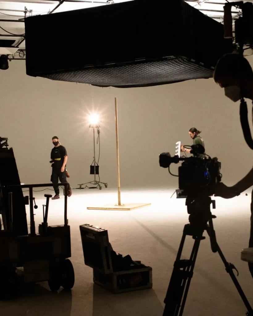 Cinematic production crew working on a film set with lighting and camera equipment, illustrating the need for smart and simple movie budgeting software for streamlined film budgeting and production planning.