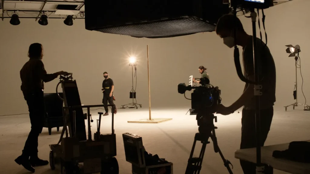Film crew working on set during pre-production, highlighting key filmmaking team roles like producer, director, and DP, along with legal essentials such as contracts, permits, and insurance.